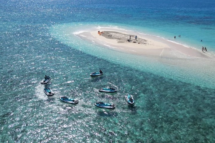 a group of people jet skiing on a body of water