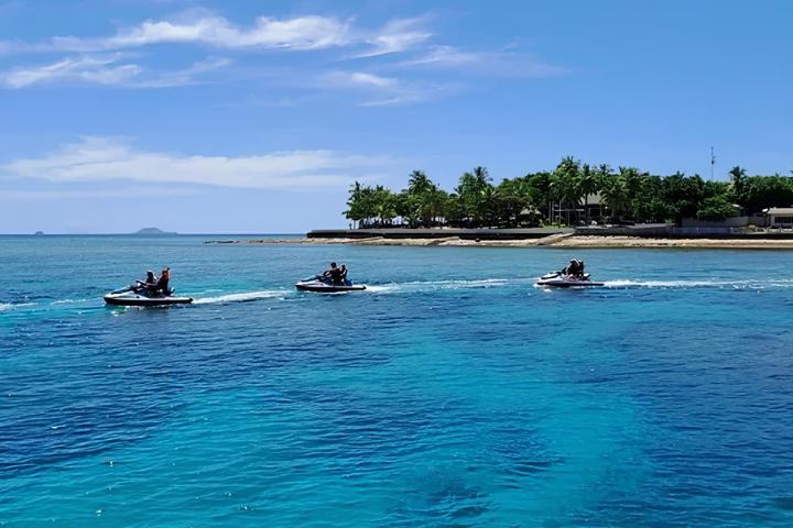 a group of people jet skiing on a body of water