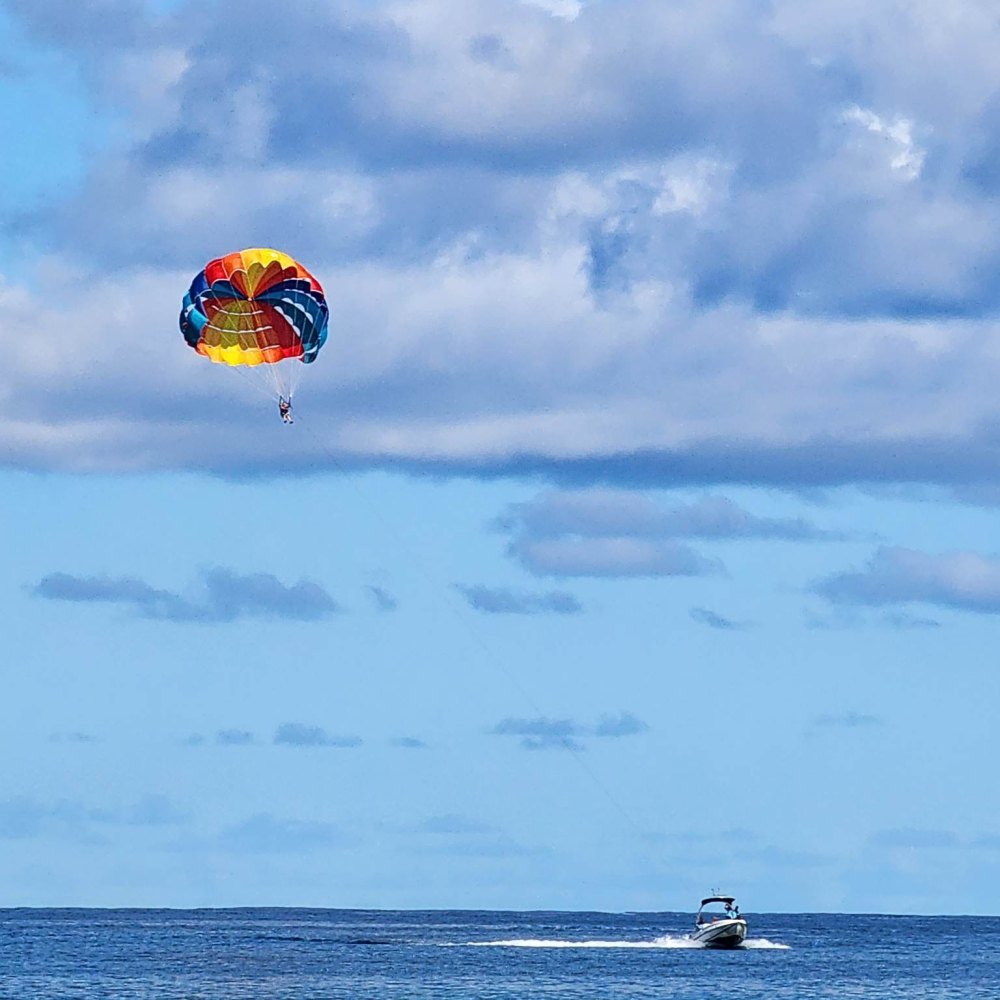 a parachute is flying over a body of water